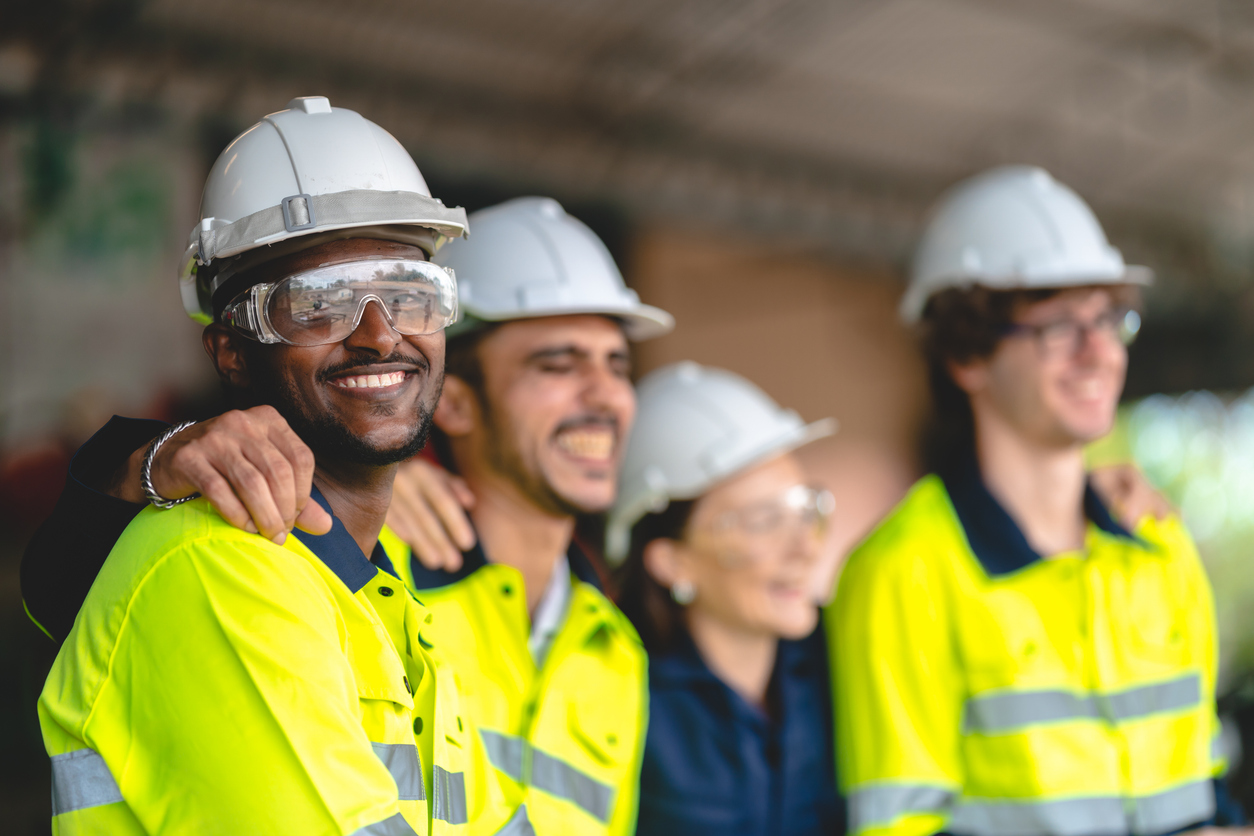 Diverse team of workers in safety gear and high-visibility clothing representing inclusive workplace training